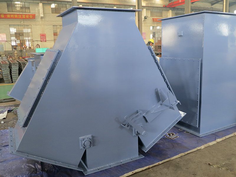 A metal machine placed in a warehouse, equipped with a four-way gravity diverter valve, reflects its functionality and design