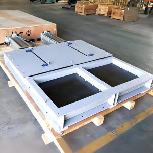 En el interior de la fábrica, una válvula de compuerta neumática de doble puerta descansa sobre un palé, lista para su instalación en sistemas de manipulación de materiales.