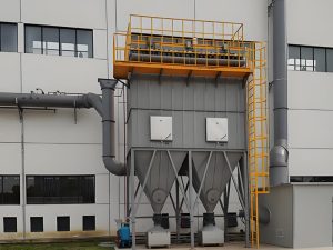 A substantial industrial structure containing an ATEX dust collector and a large industrial machine for enhanced productivity.