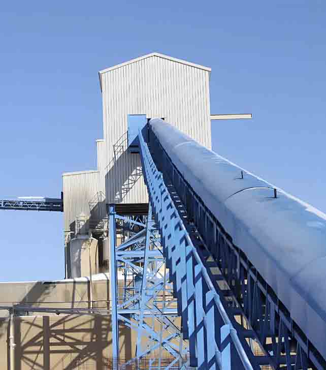 Sistema de elevador de baldes concebido para o transporte vertical de materiais, apresentando baldes ligados a um tapete transportador vertical